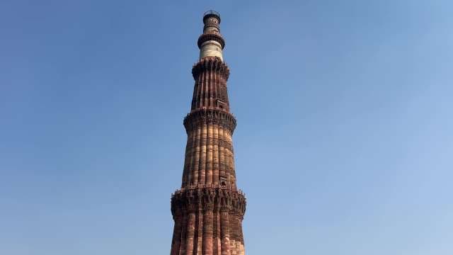 Qutab Minar: Iconic Delhi Minaret Against Clear Blue Sky