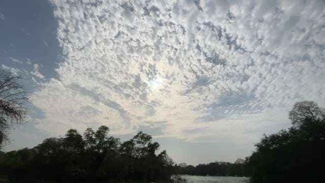 Dramatic Cloudscape Over Lush Riverside Landscape