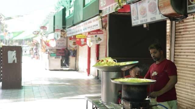 Street Food Vendor Preparing Savory Indian Cuisine Outdoors