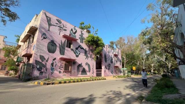Vibrant Pink Mural Building on a Quiet Tree-Lined Street
