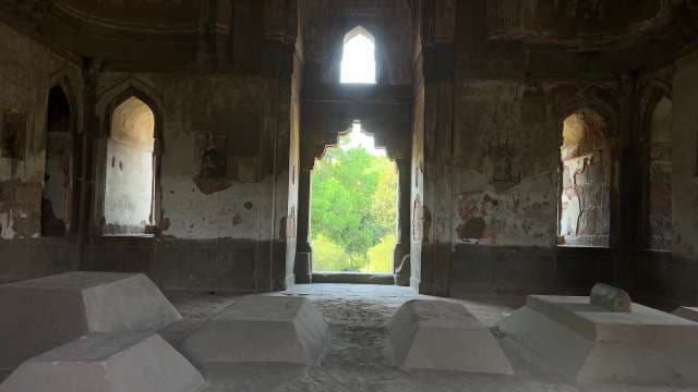 Inside an Ancient Indian Tomb with Stone Graves and Arched Windows
