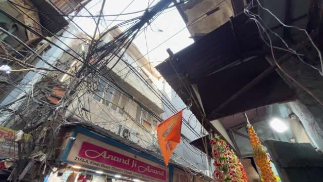 Tangled Electrical Wires Above Bustling Delhi Market Street