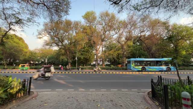 Busy Street Scene With Bus, Rickshaw, and Scooter in Delhi