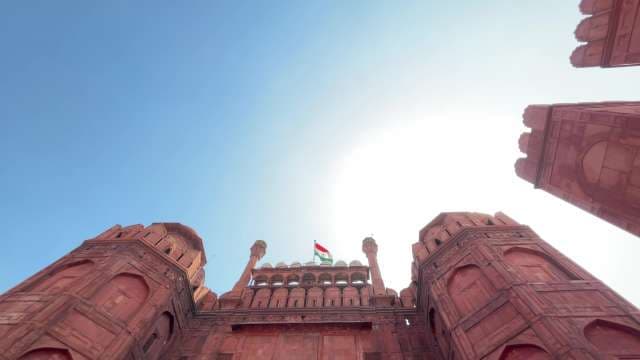 Majestic Red Fort With Indian Flag Against Blue Sky