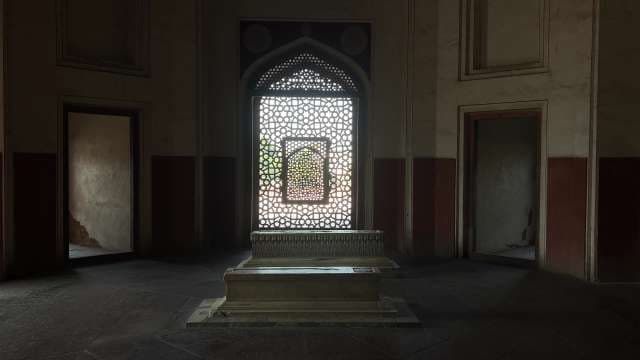 Ancient Tomb Interior With Ornate Stone Lattice Window
