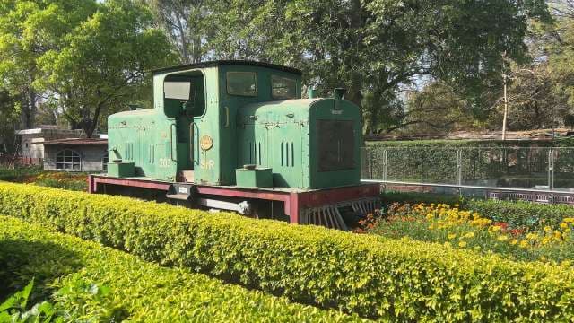 Historic Green Diesel Locomotive Displayed in Garden Setting