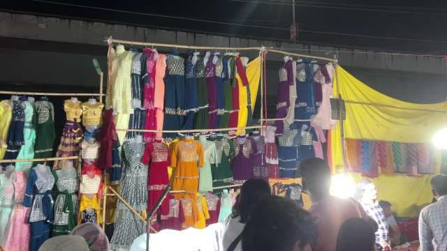 Vibrant Night Market Clothing Stall Showcases Colorful Traditional Dresses
