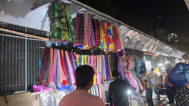 Bustling Night Market With Colorful Fabrics and Local Shoppers