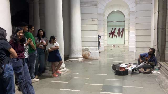 Street Musician Performs Guitar for Crowd at Connaught Place