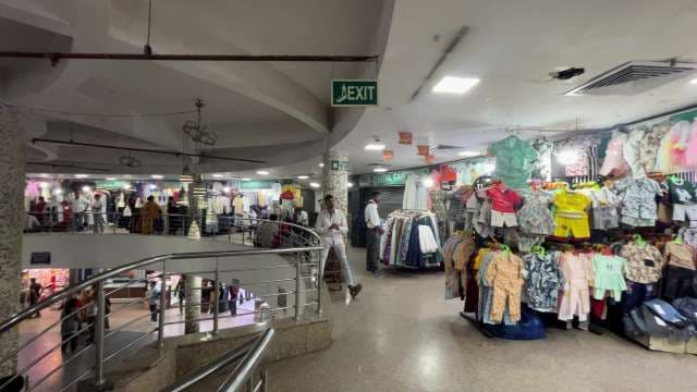 Bustling Indoor Clothing Market With Shoppers and Stalls