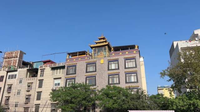 Tibetan-Style Buddhist Building in Urban Neighborhood Under Blue Sky