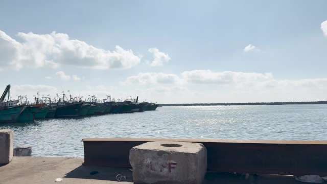 Fishing Boats Docked at Coastal Harbor Under Clear Sky
