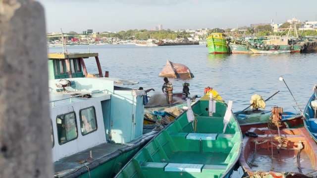 Fishermen Working on Colorful Boats in Busy Harbor