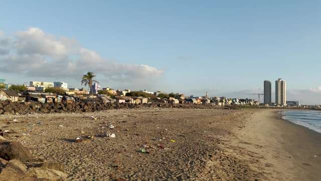 Littered Urban Beachfront and Cityscape in Evening Light
