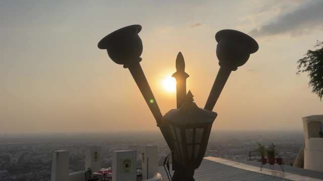 Sunset Cityscape With Vintage Lamp Overlooking Urban Skyline