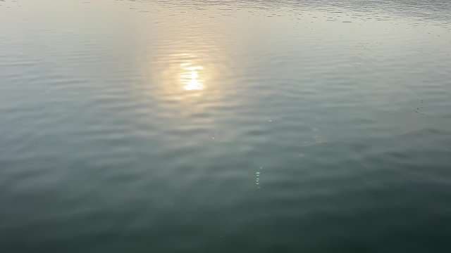 Tranquil Sunrise Reflection on Calm Water Surface