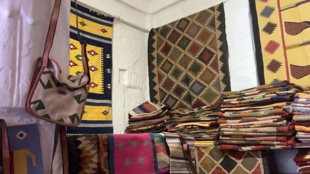 Colorful Handwoven Rugs and Textiles Displayed in Artisan Shop