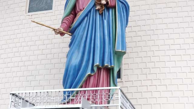 Large Saint Statue Adorns Church Balcony Exterior