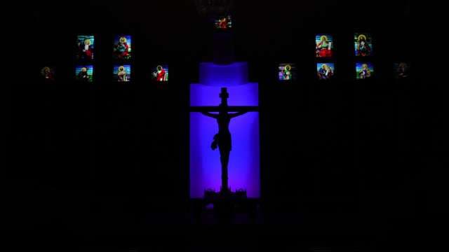 Crucifix Silhouette Illuminated by Stained Glass Light