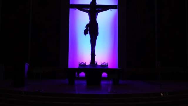 Silhouette of Crucifix Illuminated by Purple and Blue Light