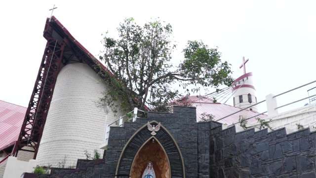 Modern Church Architecture with Iconic Crosses and Stone Grotto