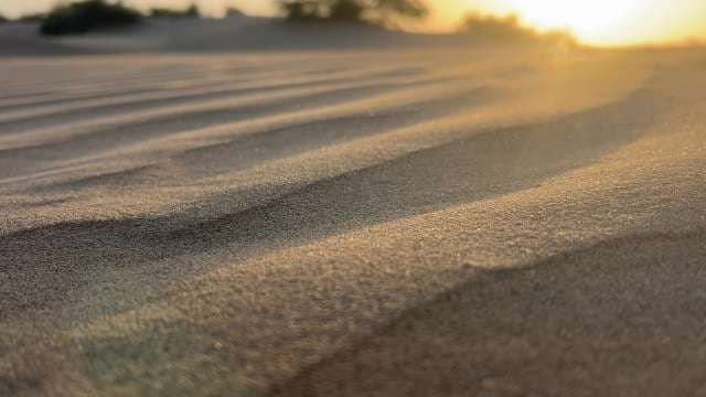 Golden Sunset Over Rippling Desert Sand Dunes