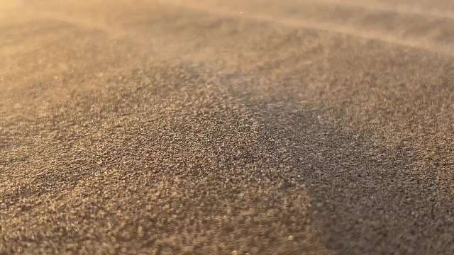 Close-Up View of Desert Sand Textures at Sunset