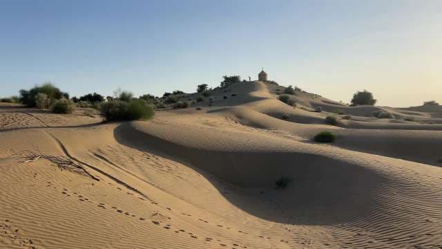 Golden Desert Dunes With Remote Chapel at Sunset