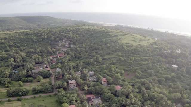 Aerial View of Lush Coastal Village and Rolling Hills