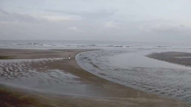 Solitary Walk Along Tranquil Ocean Shoreline at Dusk