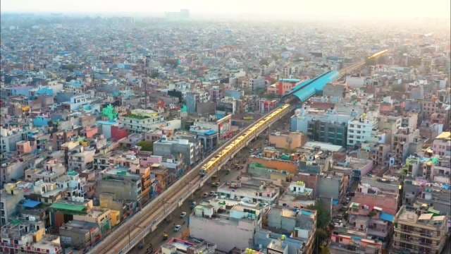 Delhi Metro Train Glides Through Bustling Urban Landscape