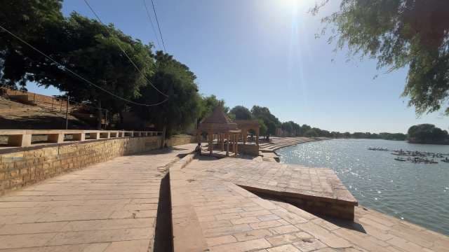 Serene Temple Ghat Beside Tranquil Lake Under Morning Sun