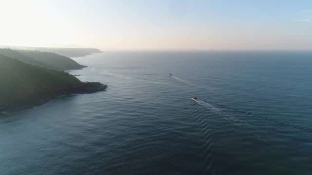 Aerial Coastal View with Boats and Dramatic Cliffside
