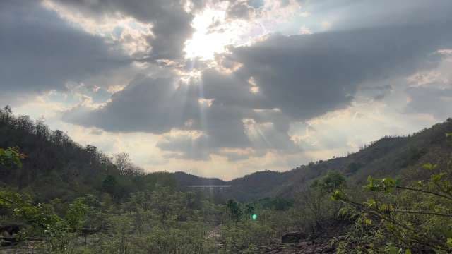 Dramatic Crepuscular Rays Through Clouds Over Valley