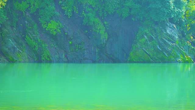 Emerald Lake Surrounded by Lush Forest Cliffs