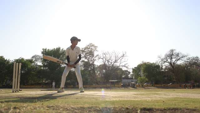 Dynamic Cricket Batting Shot – Indian Kid in Motion with Soft Sun Flare 