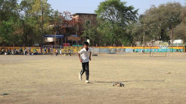 Young Boy Bowling in Cricket Ground