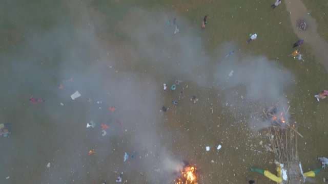 Aerial View of Large Crowd Celebrating Festival With Bonfire and Smoke