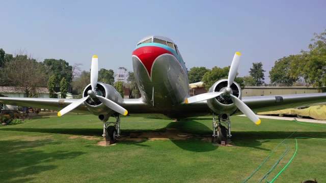 Classic Vintage Douglas DC-3 Propeller Airplane Parked on Grass