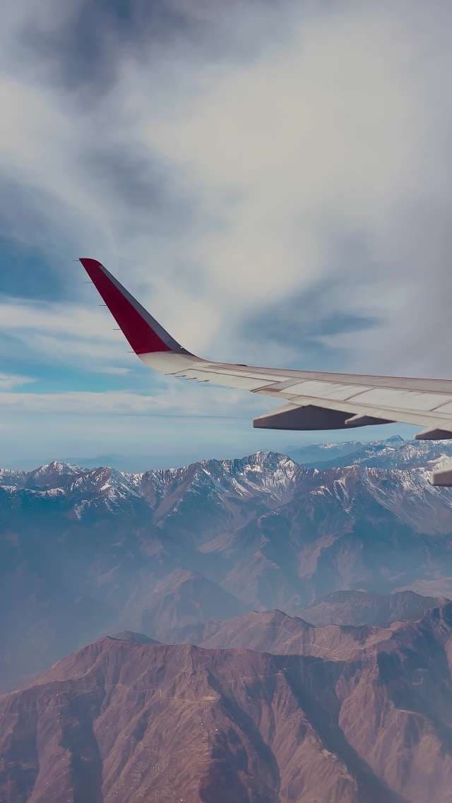 Breathtaking Aerial View of Snow-Capped Mountains From Airplane Window