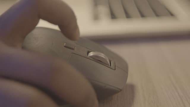 Close-up of Hand Using Wireless Computer Mouse at Desk
