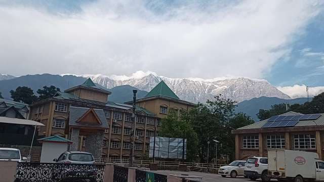 Scenic Dharamshala Buildings with Snowy Himalayan Mountain Range Background
