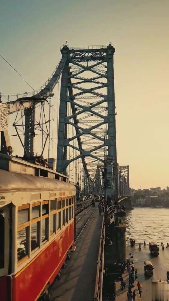 Vintage Tram Crossing Iconic Howrah Bridge in Kolkata at Sunset