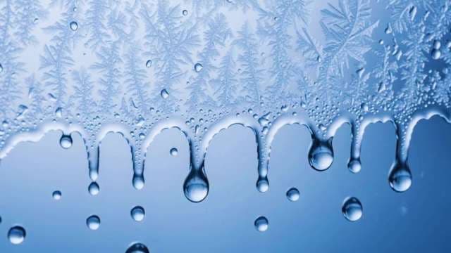 Macro of Frost Melting and Water Droplets on Blue Glass