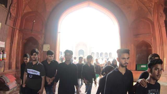 Young Men Walking Through Jama Masjid Archway in Delhi
