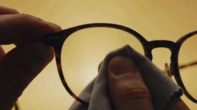 Cleaning Tortoiseshell Eyeglasses Lens with Microfiber Cloth Close Up