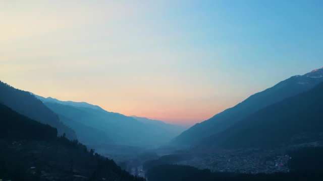 Peaceful Sunset Over Misty Mountain Valley and Remote Village
