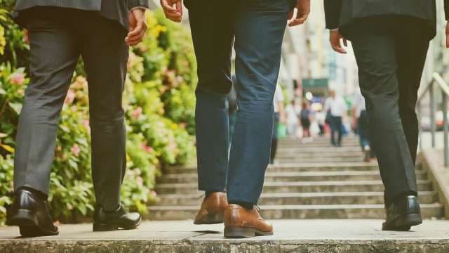 Businessmen in Suits Walking Up Urban Stairs