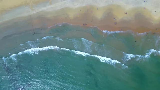 Aerial View of Turquoise Ocean Waves Crashing on Sandy Beach, Visakhapatnam