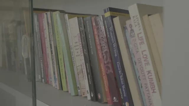 Row of Colorful Books on a Shelf Behind Glass Partition